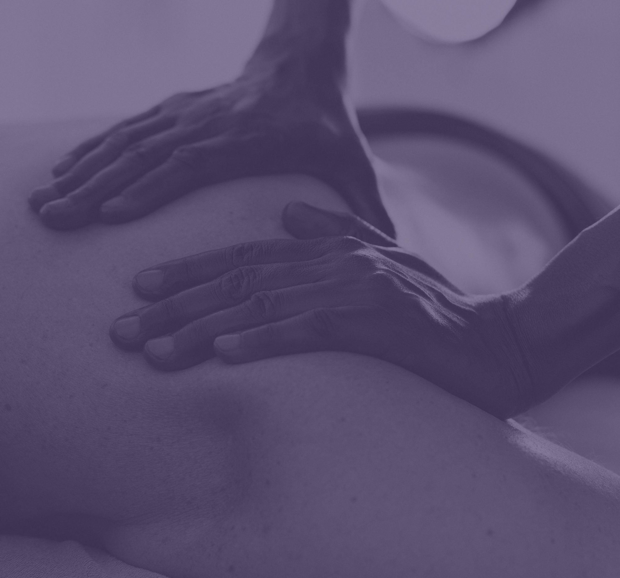 Mains posées sur le dos d’une personne allongée, sous un voile mauve